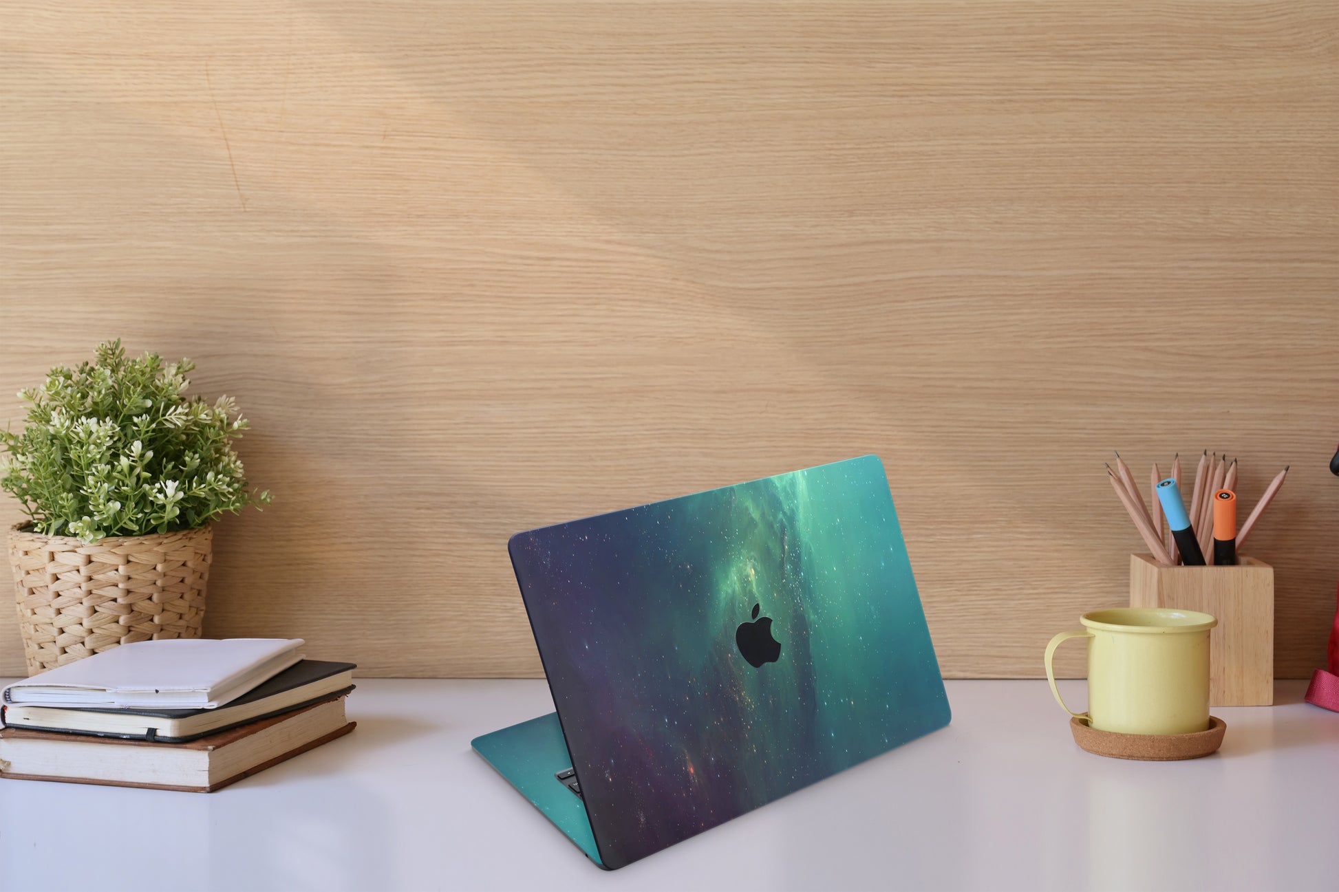 Close-up view of a Nebula Green Stars MacBook skin decal, featuring a vivid green nebula with shimmering stars scattered throughout, creating a celestial and enchanting scene.